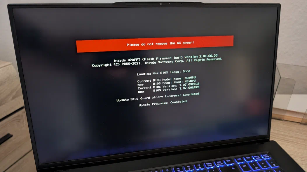 A monitor of a laptop showing the progress of a BIOS update. The process is completed.